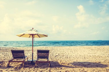 Şemsiye ve sandalye üzerinde plaj ve deniz