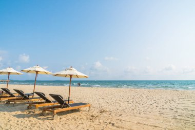 Şemsiye ve sandalye üzerinde plaj ve deniz