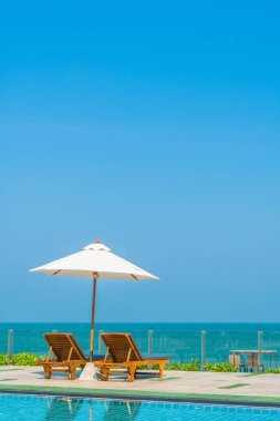 Güzel şemsiye ve sandalye etrafında yüzme havuzunda otel ve r