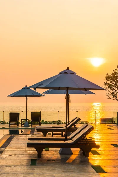 Bellissimo ombrellone e sedia intorno alla piscina in hotel e r — Foto Stock