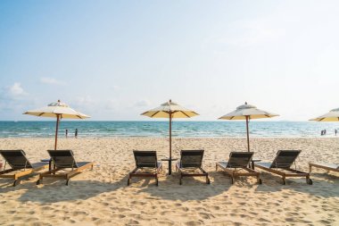 Şemsiye ve sandalye üzerinde plaj ve deniz