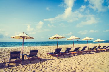 Şemsiye ve sandalye üzerinde plaj ve deniz