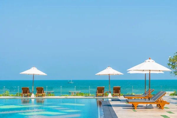 Schöner Sonnenschirm und Liegestuhl rund um das Schwimmbad im Hotel und r — Stockfoto