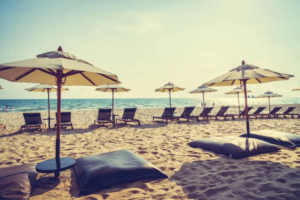 Guarda-chuva e cadeira na praia e no mar — Fotografia de Stock