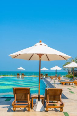 Güzel şemsiye ve sandalye etrafında yüzme havuzunda otel ve r