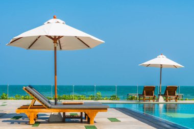 Güzel şemsiye ve sandalye etrafında yüzme havuzunda otel ve r