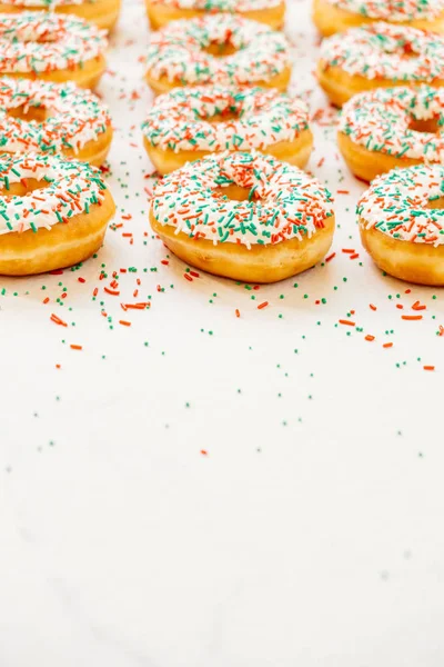 Donuts with white chocolate cream and sprinkles sugar