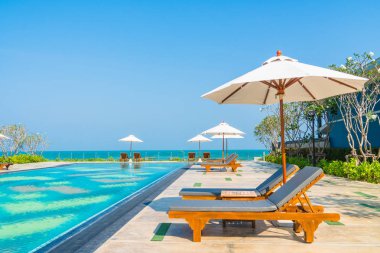 Güzel şemsiye ve sandalye etrafında yüzme havuzunda otel ve r