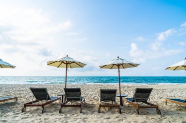 Şemsiye ve sandalye üzerinde plaj ve deniz