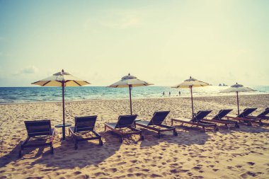 Şemsiye ve sandalye üzerinde plaj ve deniz