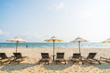 Şemsiye ve sandalye üzerinde plaj ve deniz