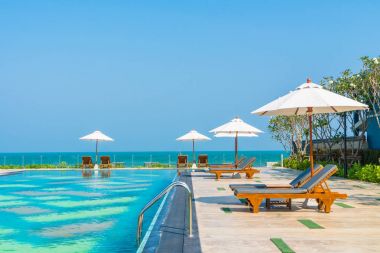 Güzel şemsiye ve sandalye etrafında yüzme havuzunda otel ve r