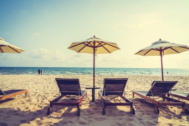 Şemsiye ve sandalye üzerinde plaj ve deniz