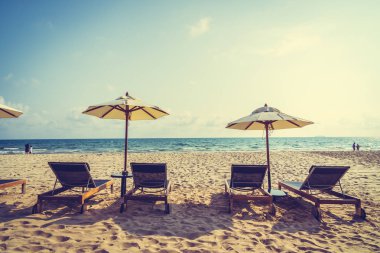 Şemsiye ve sandalye üzerinde plaj ve deniz