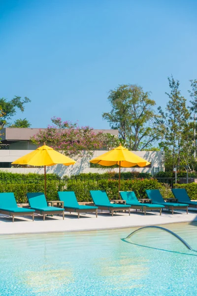 Paraguas y silla alrededor de la piscina — Foto de Stock