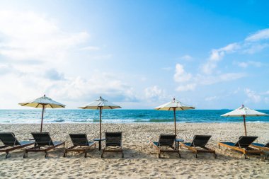 Şemsiye ve sandalye üzerinde plaj ve deniz