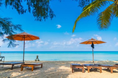 Şemsiye ve sandalye üzerinde plaj ve deniz