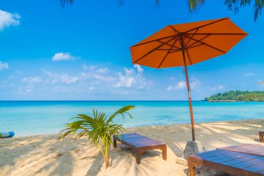Şemsiye ve sandalye üzerinde plaj ve deniz
