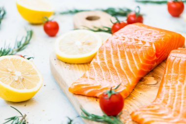 Ahşap kesme tahtası üzerinde ham ve taze somon eti fileto