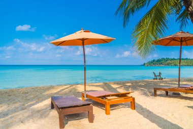 Şemsiye ve sandalye üzerinde plaj ve deniz