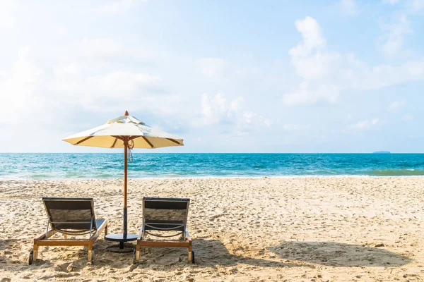Sonnenschirm und Liegestuhl am Strand und Meer — Stockfoto