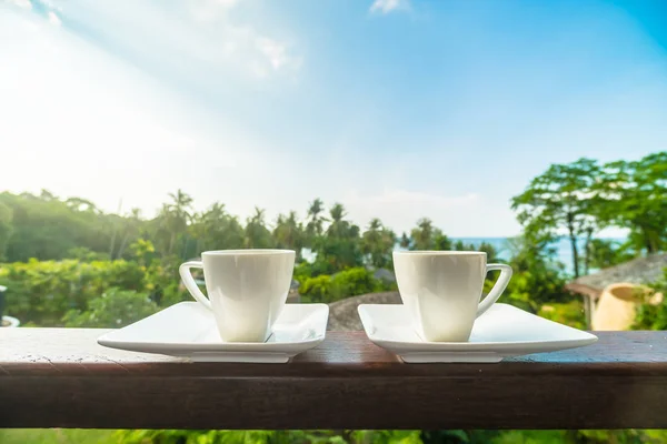 White coffee cup with beautiful paradise island sea and beach