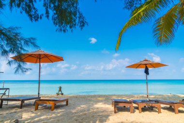 Şemsiye ve sandalye üzerinde plaj ve deniz