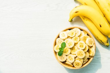 Ahşap kase çiğ sarı muz dilimleri