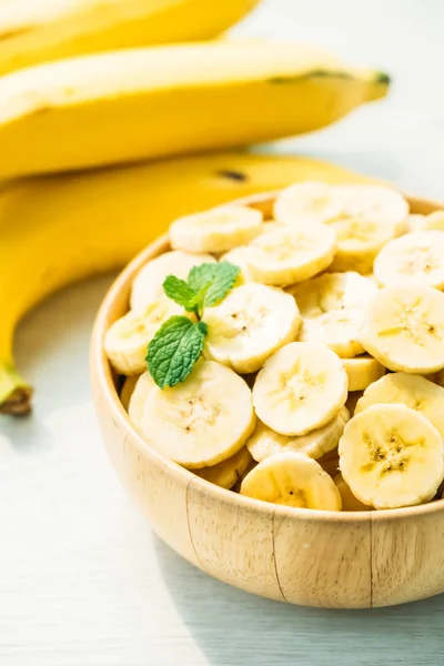Raw yellow banana slices in wooden bowl — Stock Photo, Image