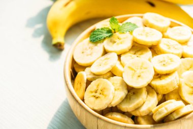 Ahşap kase çiğ sarı muz dilimleri