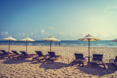 Şemsiye ve sandalye üzerinde plaj ve deniz