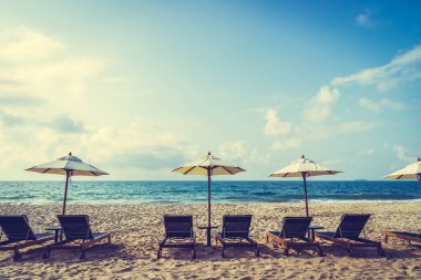 Şemsiye ve sandalye üzerinde plaj ve deniz