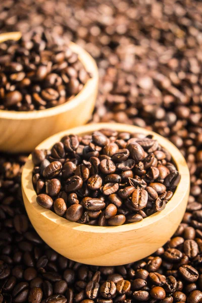 Granos de café marrón en cuenco de madera —  Fotos de Stock