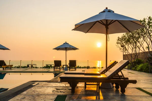 Bellissimo ombrellone e sedia intorno alla piscina in hotel e r — Foto Stock