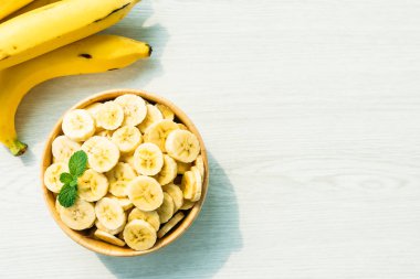 Ahşap kase çiğ sarı muz dilimleri