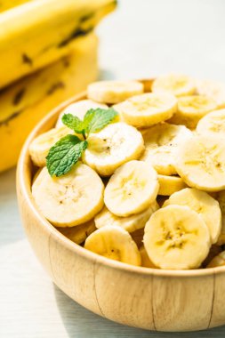 Ahşap kase çiğ sarı muz dilimleri