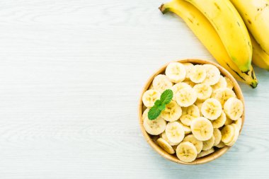 Ahşap kase çiğ sarı muz dilimleri