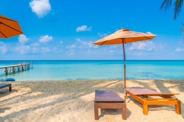 Şemsiye ve sandalye üzerinde plaj ve deniz