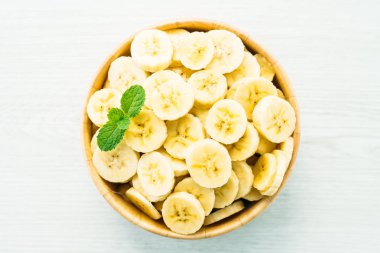 Ahşap kase çiğ sarı muz dilimleri