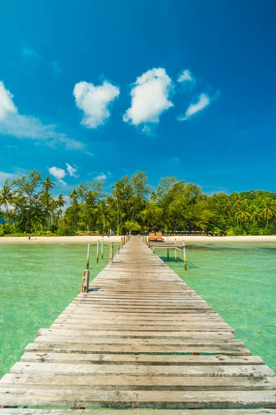 Wooden pier or bridge with tropical beach and sea in paradise is — Stock Photo, Image