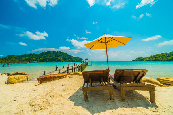 Umbrella and chair on the Beautiful tropical beach and sea with coconut palm tree in paradise island for travel and vacation