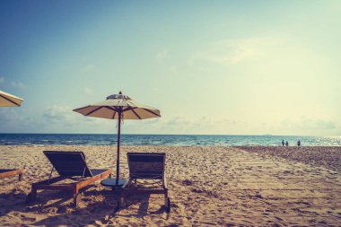 Şemsiye ve sandalye üzerinde plaj ve deniz