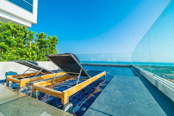 Cadeira e cama em torno da piscina no hotel — Fotografia de Stock