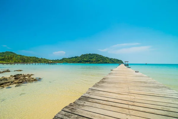 Träbrygga eller bridge med tropiska stranden och havet i paradiset är — Stockfoto