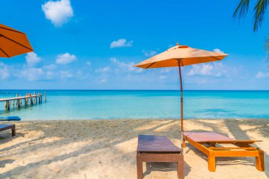 Şemsiye ve sandalye üzerinde plaj ve deniz