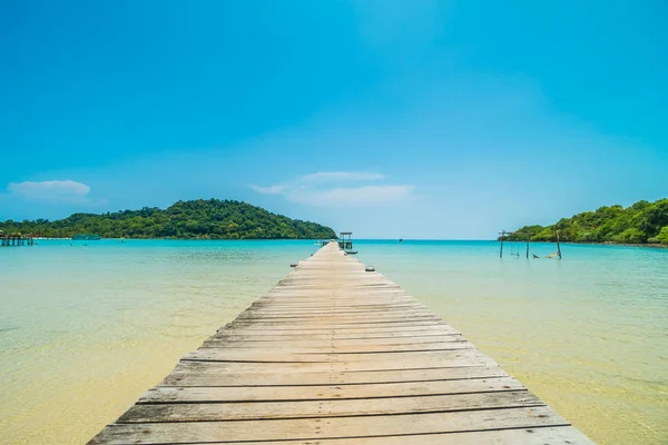 Träbrygga eller bridge med tropiska stranden och havet i paradiset är — Stockfoto