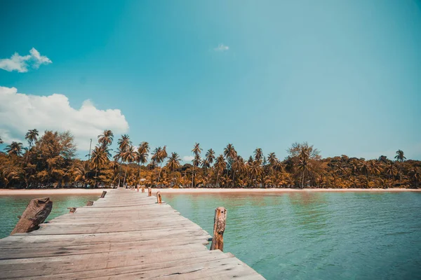 Wooden pier or bridge with tropical beach and sea in paradise is — Stock Photo, Image