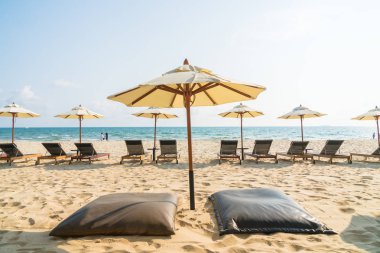 Şemsiye ve sandalye üzerinde plaj ve deniz