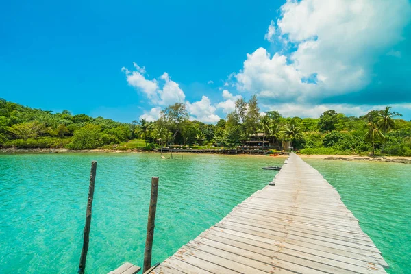 Träbrygga eller bridge med tropiska stranden och havet i paradiset är — Stockfoto
