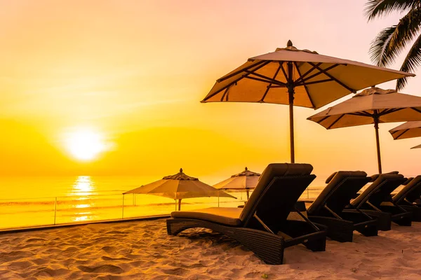 Parasol en stoel op het mooie strand en de zee bij zonsopgang tim — Stockfoto